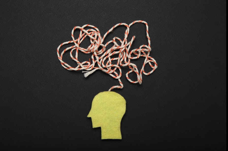 A paper cutout of the side profile of a human head, with a bundle of strings above to represent confusion.