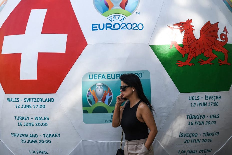 Une femme devant un ballon géant annonçant le match Pays de Galles - Suisse