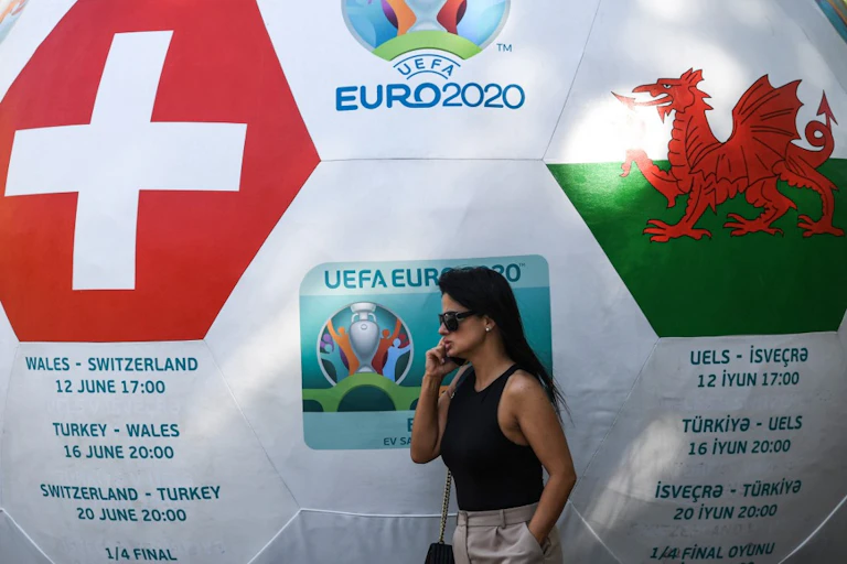 Une femme devant un ballon géant annonçant le match Pays de Galles - Suisse