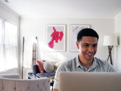 Young man sitting at a laptop.