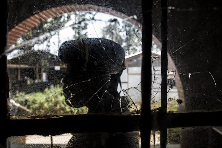 Soldat congolais derrière une vitre trouée d'une balle