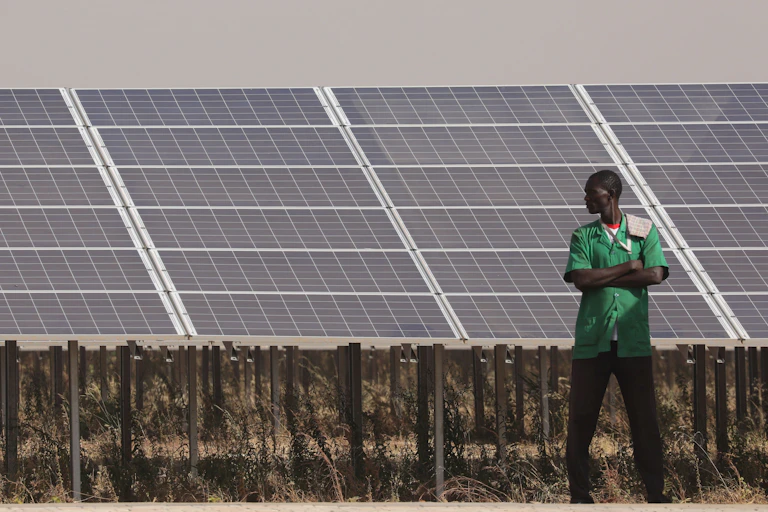 A man stands next to a solar power plant.