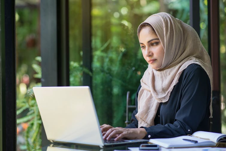 A woman works on a computer.