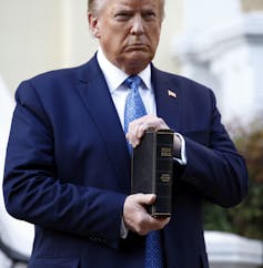 Donald Trump holding bible outside St. John's Church across Lafayette Park from the White House in Washington.