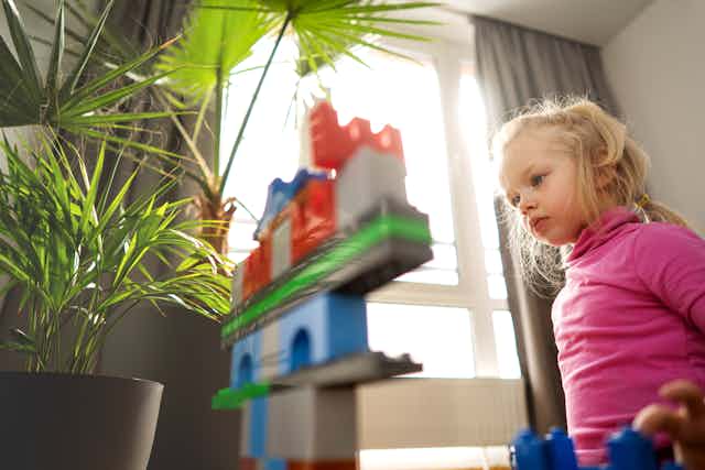 Girl concentrates on building blocks.
