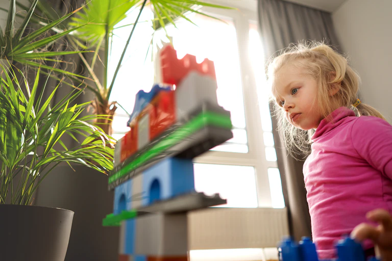 Girl concentrates on building blocks.