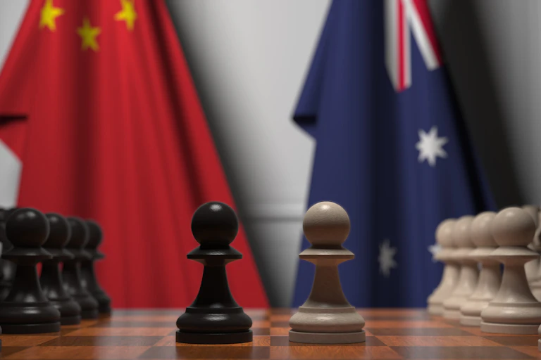 A chessboard, with an Australian and a Chinese flag in the background