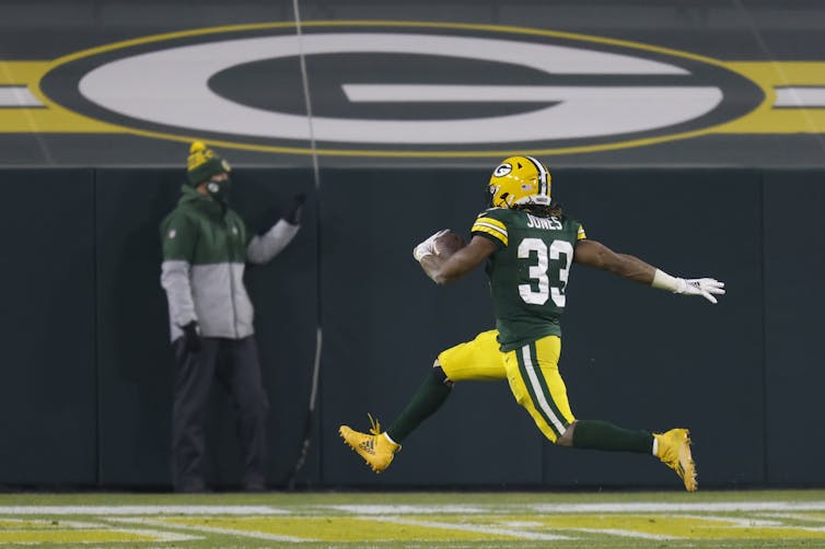 Green Bay Packer Aaron Jones running for a touchdown in a game against the Carolina Panthers on December 19 2020.