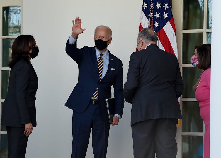 President Biden, waving while standing with Vice President Harris, Sen. Schumer and Rep. Pelosi
