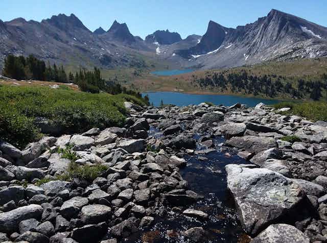 Scenic photo of mountains with snow and a river.
