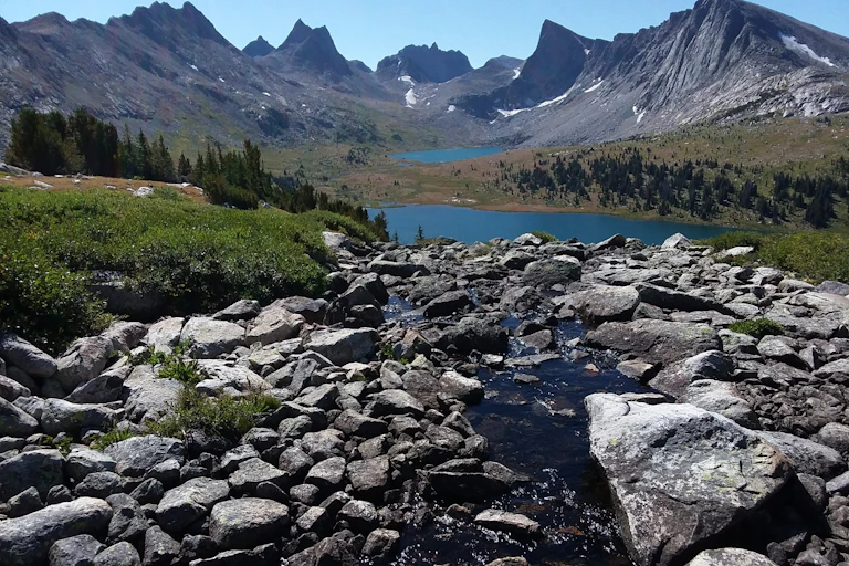 Scenic photo of mountains with snow and a river.