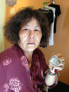 A woman shows a picture to the camera.