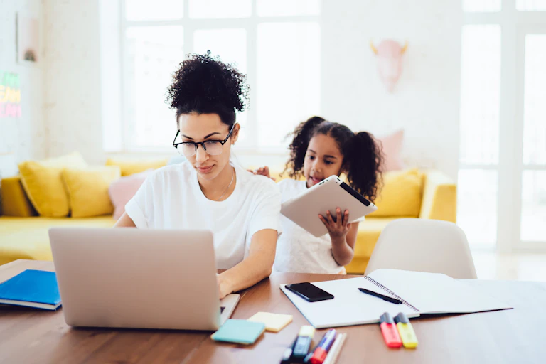 A mother sitting at desk with daughter talking to her