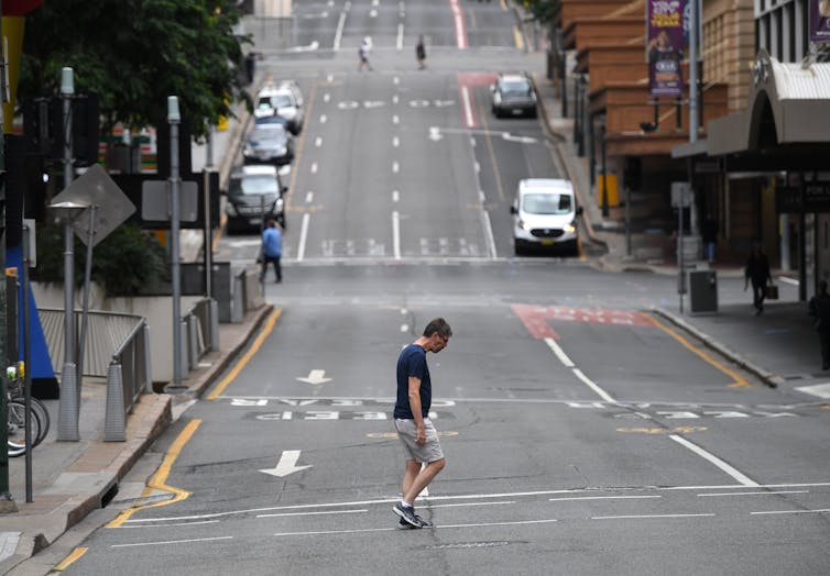 Man crosses an almost deserted city street