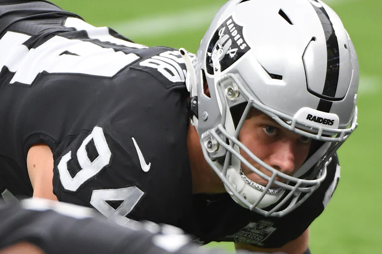 Carl Nassib lines up in a three-point stance during warm-ups for a football game.