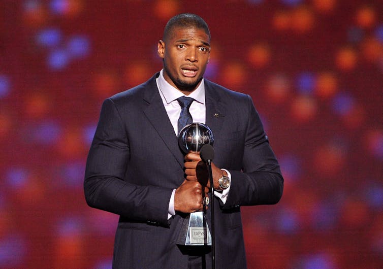 Michael Sam clutches his award as he speaks during the ESPYs.