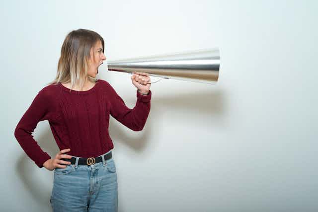 A woman tells into a megaphone