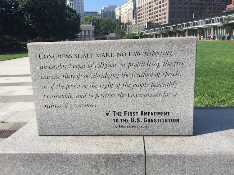 A stone carved with the text of the First Amendment