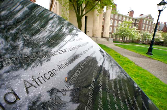 Words engraved on a stone plinth form a component of the Slavery Memorial by sculptor Martin Puryear, erected in 2014, on the Brown University campus in Providence, R.I.