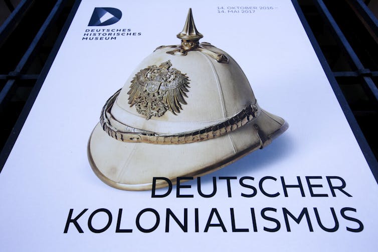 A poster for the exhibition 'German Colonialism' with a historic German spiked helmet displayed outside the German Historic Museum in Berlin, Friday, Jan. 6, 2017.