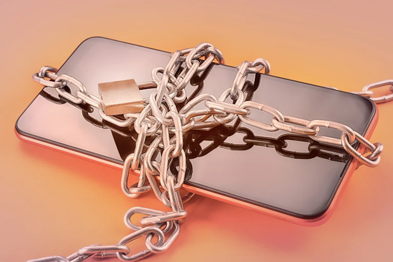 A cellphone bound in a chain with a lock.