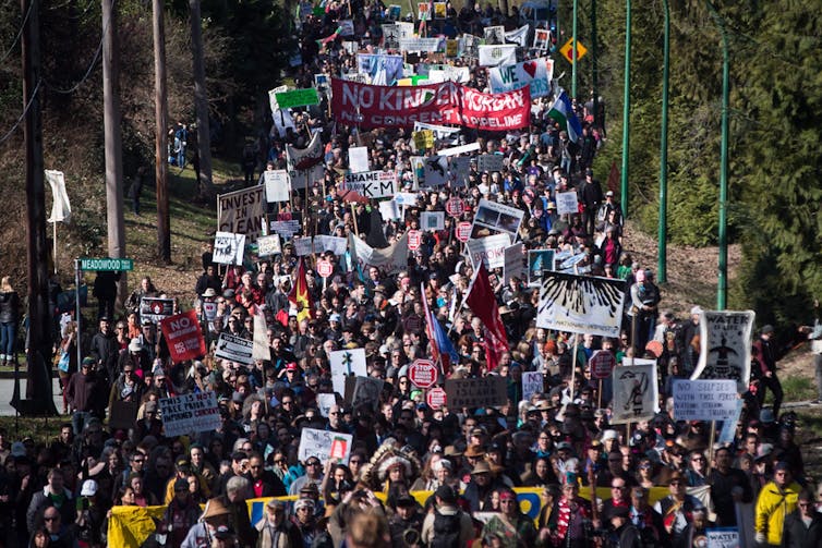 Thousands of people, including Indigenous leaders and environmentalists, march together during a protest