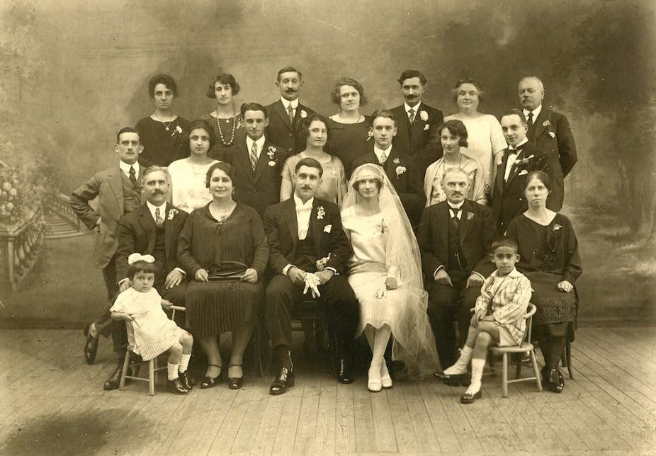 Deux mariés français posent en studio avec leurs familles, autour de 1925.