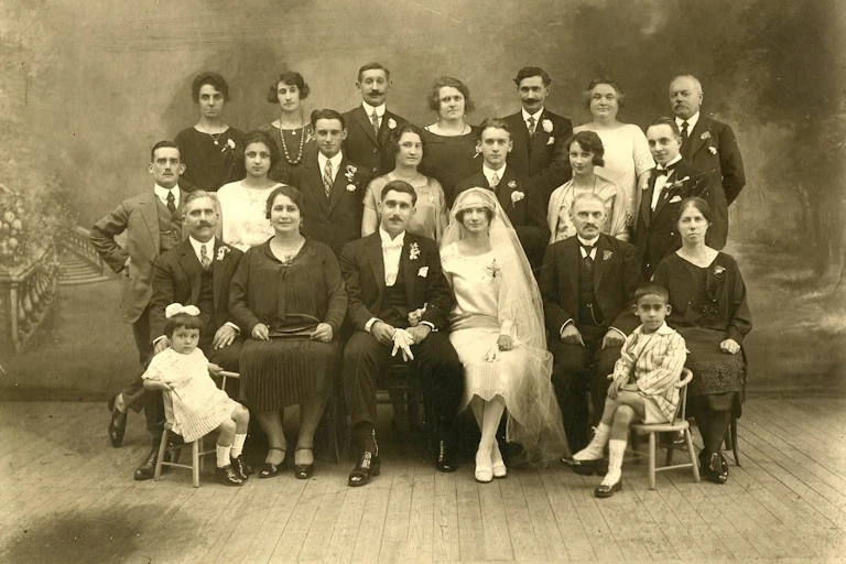 Deux mariés français posent en studio avec leurs familles, autour de 1925.