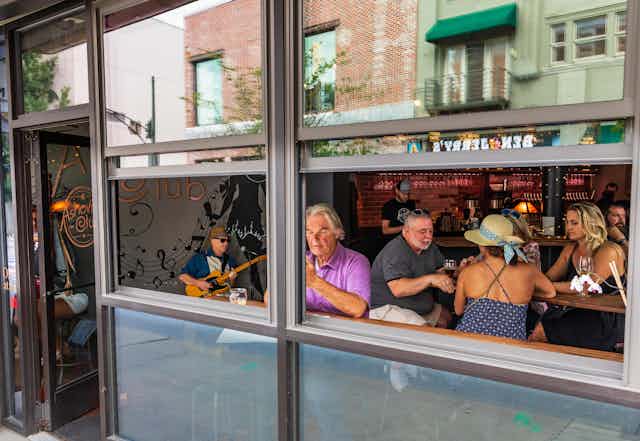 People sitting in a bar with the window open