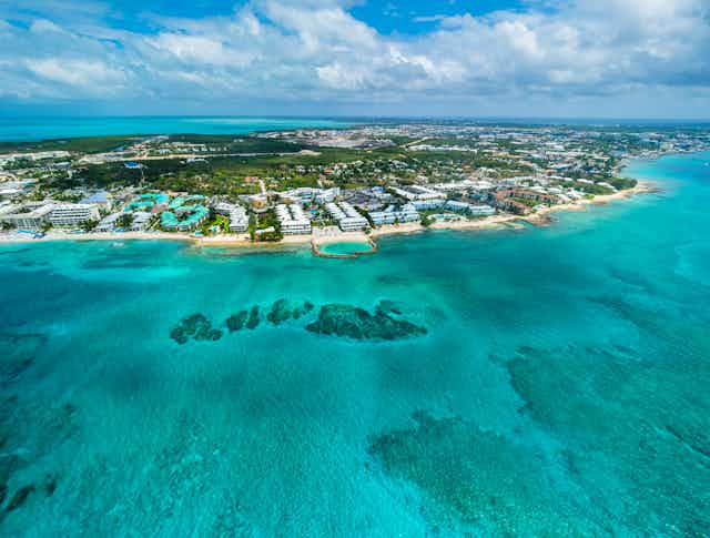 A relatively small island with luxury resorts along the short sits in the turquoise waters of the Caribbean 