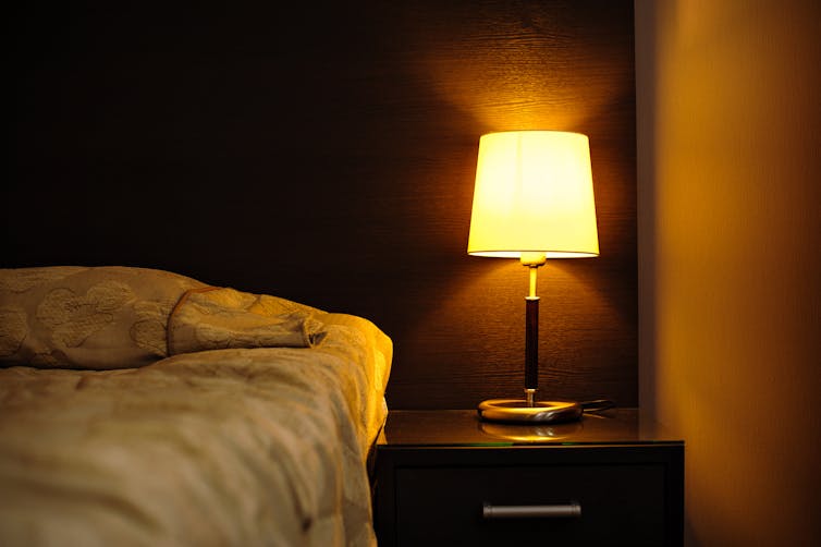 Bedroom with bedside lamp on.
