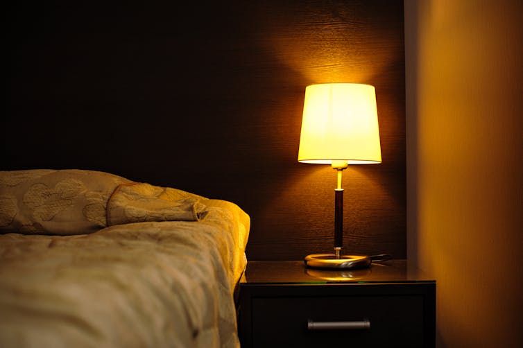 Bedroom with bedside lamp on.
