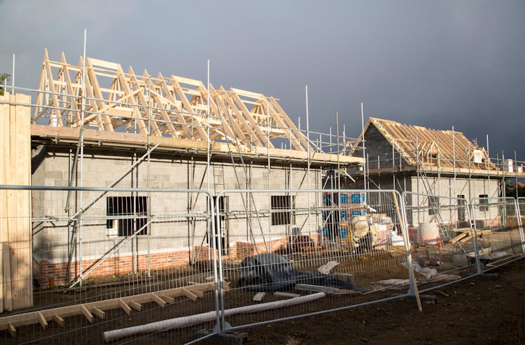 Storm clouds brew over village houses under construction