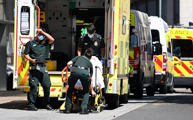 Paramedics transferring a patient from an ambulance into hospital