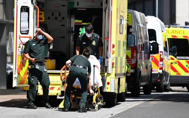 Paramedics transferring a patient from an ambulance into hospital
