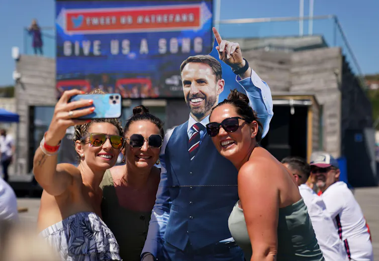 Football fans pose with a cardboard cut out of Gareth Southgate.