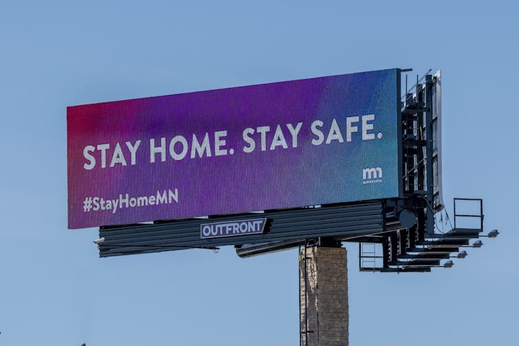 billboard with public health message 'Stay home, stay safe.'