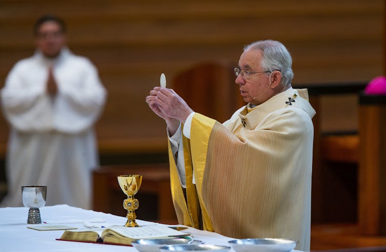 Archbishop Jose H. Gomez holds a Communion wafer during Mass  at the Cathedral of Our Lady of the Angels in downtown Los Angeles in 2020.