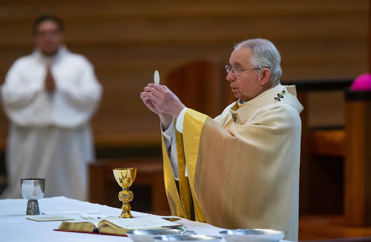 Archbishop Jose H. Gomez holds a Communion wafer during Mass at the Cathedral of Our Lady of the Angels in downtown Los Angeles in 2020.