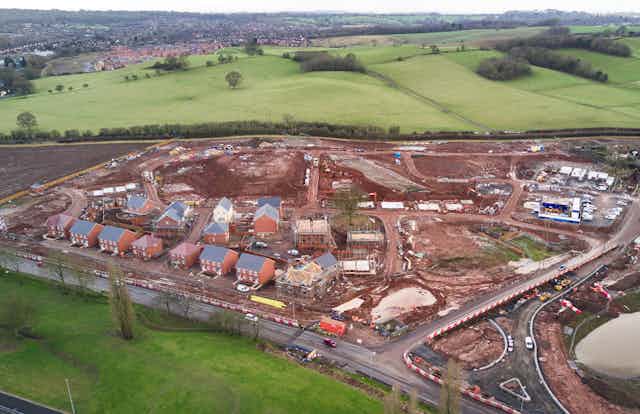 Photo An overhead view of a new development surrounded by green fields