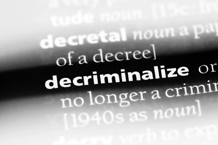 white text on a black background that reads DECRIMINALIZE NO LONGER A CRIMIN