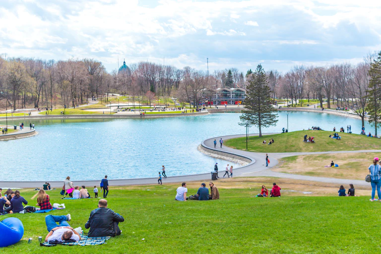 Des gens sont assis devant le lac aux Castors, sur le Mont Royal