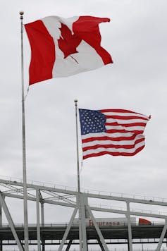 A Canadian and an American flag fly at the Blue Water Bridge between Port Huron, Michigan and Sarnia, Ontario.