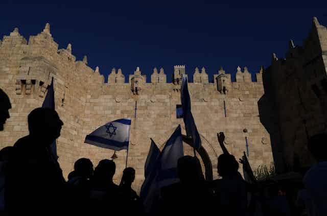 Demonstrators in silhouette in front of the Damascus gate
