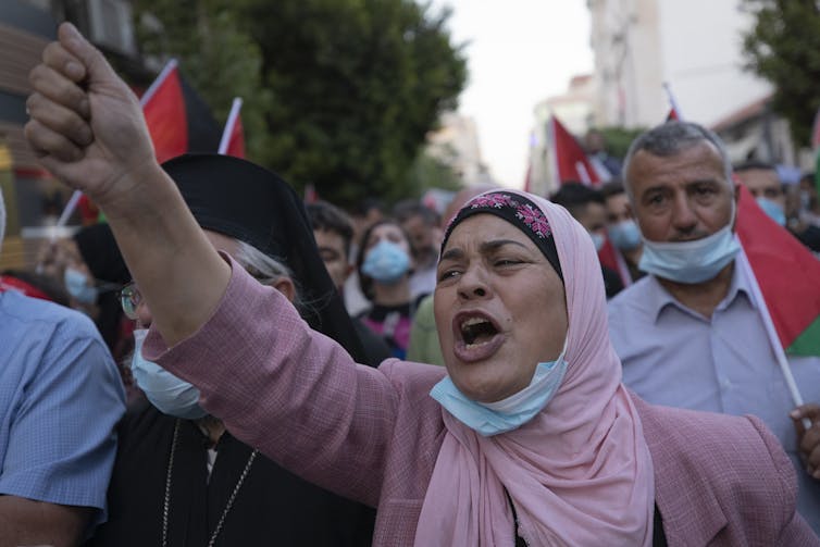 A woman raises her fist in protest.