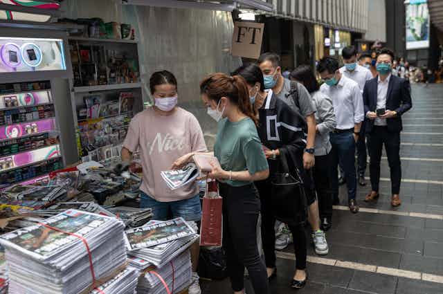Hongkongers queue at a newstand to buy the final edition of the Apple Daily tabloid newspaper.