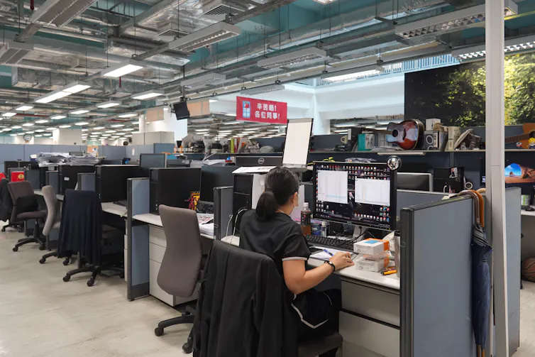 A journalist sits at a workstation in Apple Daily newsroom, June 2021.