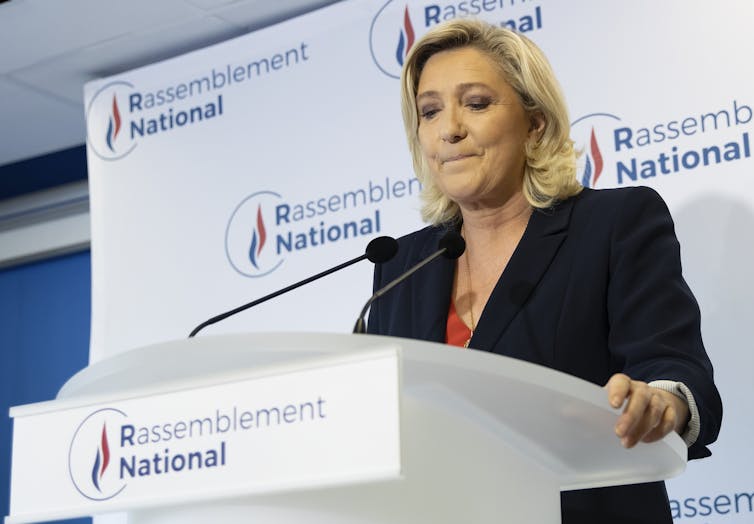 ar-right Rassemblement National (RN) party president Marine Le Pen standing at a podium makes a statement about the election, June 2021