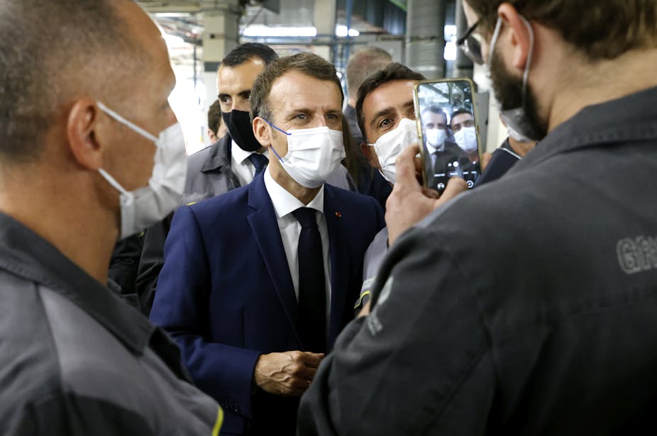 French President Emmanuel Macron poses for a selfie during his visit to the site of the future factory of Japan-based battery maker Envision AESC group, June 2021.