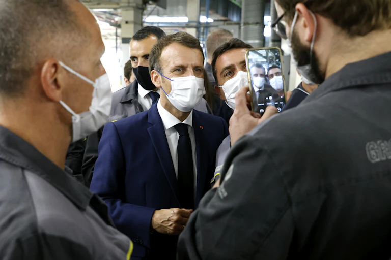 French President Emmanuel Macron poses for a selfie during his visit to the site of the future factory of Japan-based battery maker Envision AESC group, June 2021.